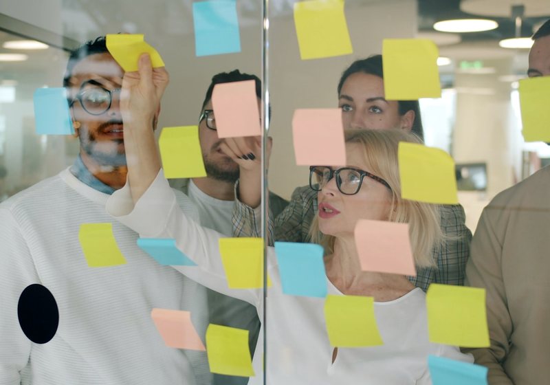 Team brainstorming with sticky notes on a glass wall