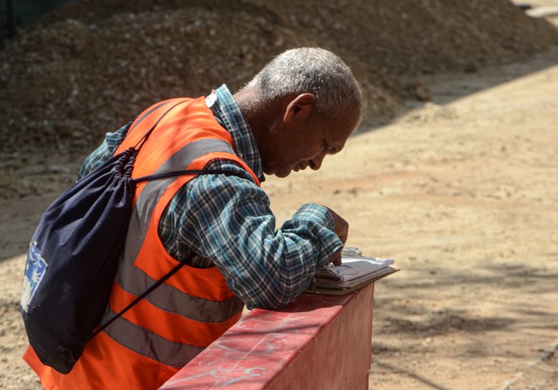 Contractor taking notes on a clipboard at a job site
