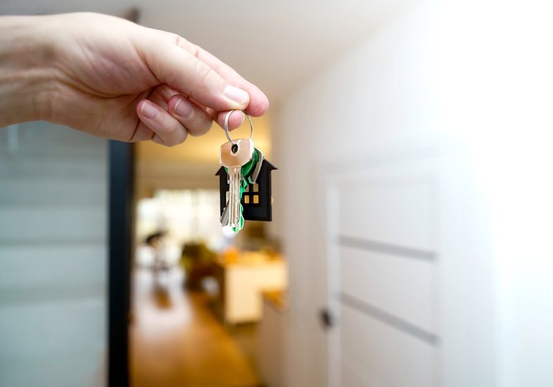 Hand holding house keys, handing them over
