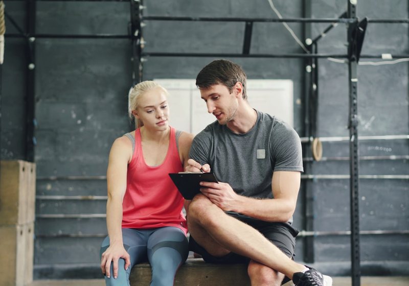 Personal trainer reviewing a workout plan with a client