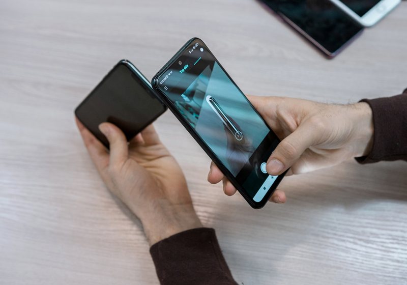 Hands holding two different smartphones side by side
