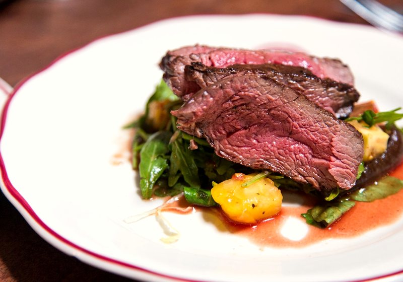 Plated steak dish photographed close up on a restaurant table