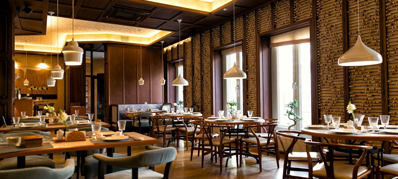 Warm, modern restaurant interior with set dining tables