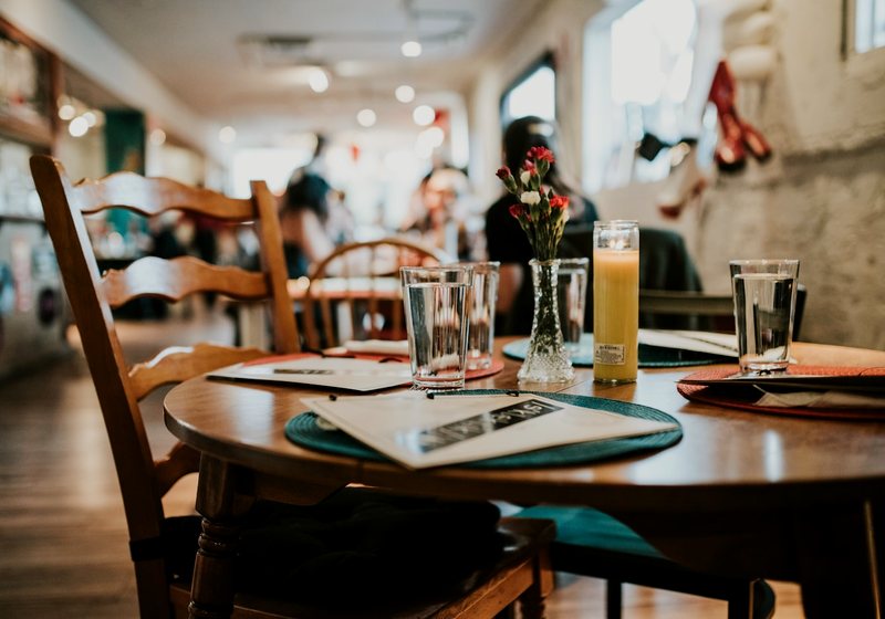 Printed restaurant menu resting on a set dining table