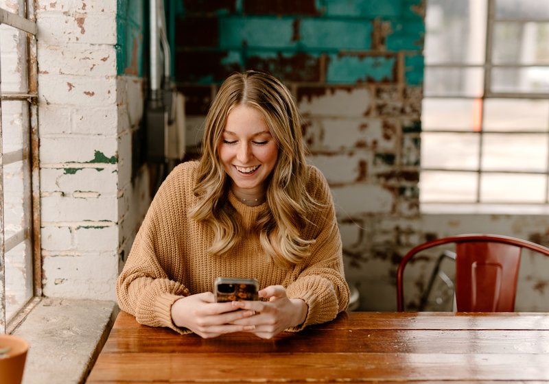 Woman smiling while checking her phone