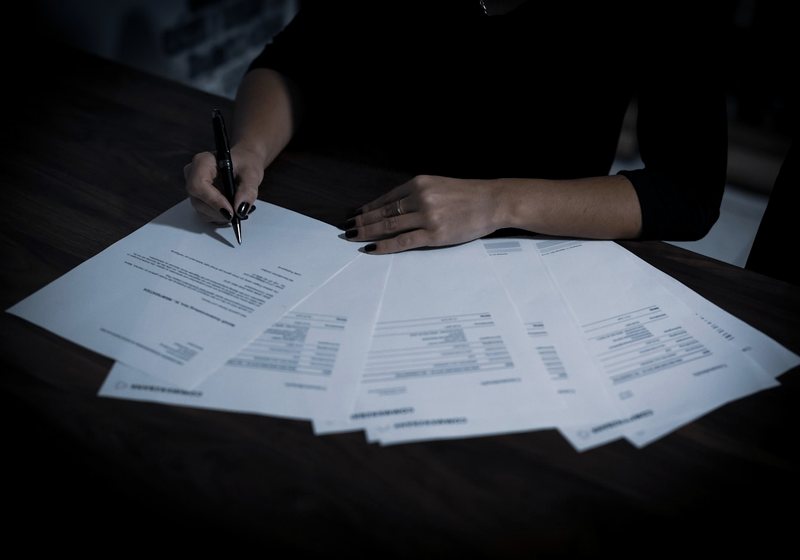 Person reviewing and signing pages of a document